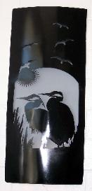 Metal wall art with egrets on it.
